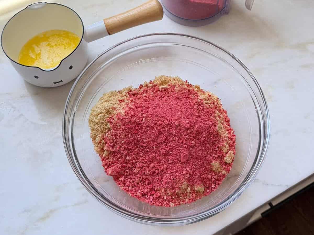 Freeze dried strawberry powder and crushed Golden Oreos in a large bowl.