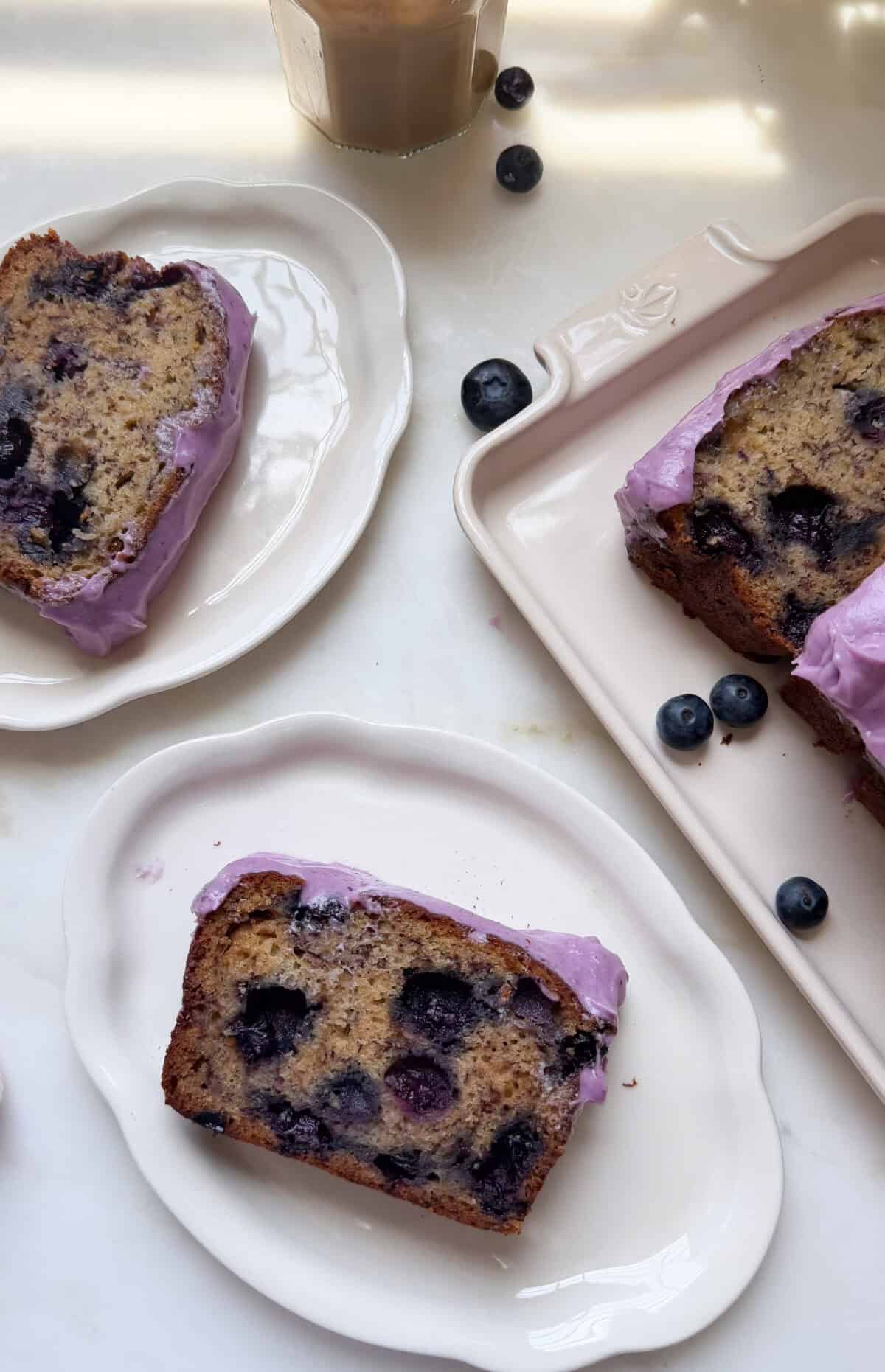 Slices of blueberry banana bread on plates.