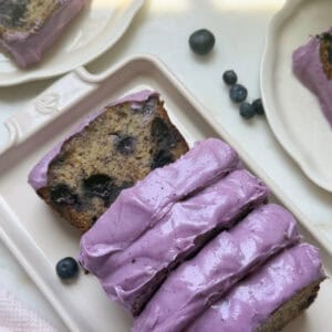 Sliced blueberry banana bread loaf on a platter.