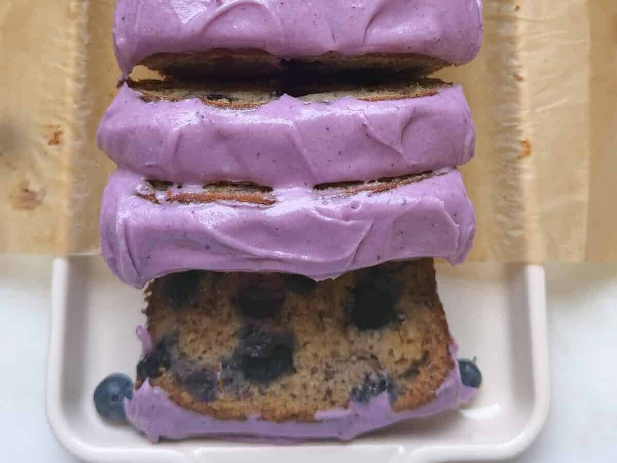 Sliced blueberry banana bread loaf on a platter.