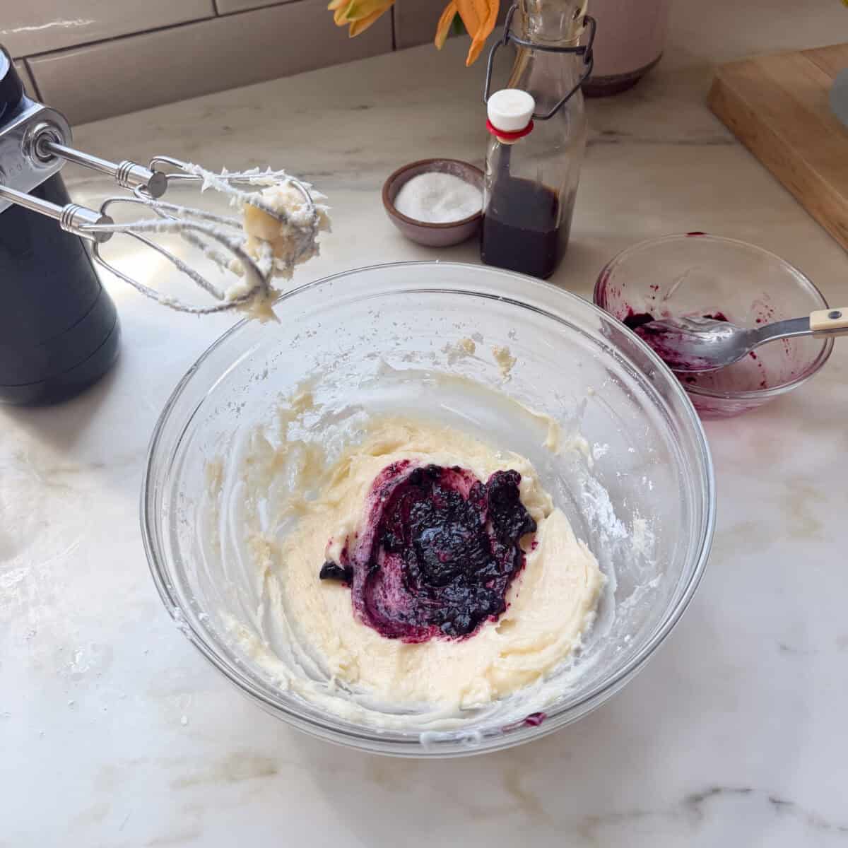 Blueberry cream cheese frosting being mixed in a bowl.