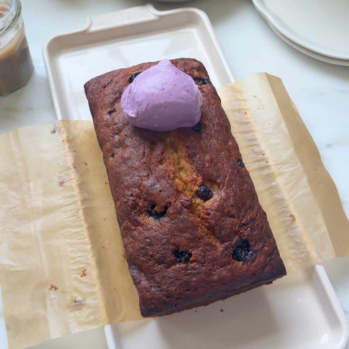 Dollop of blueberry cream cheese frosting on baked loaf.