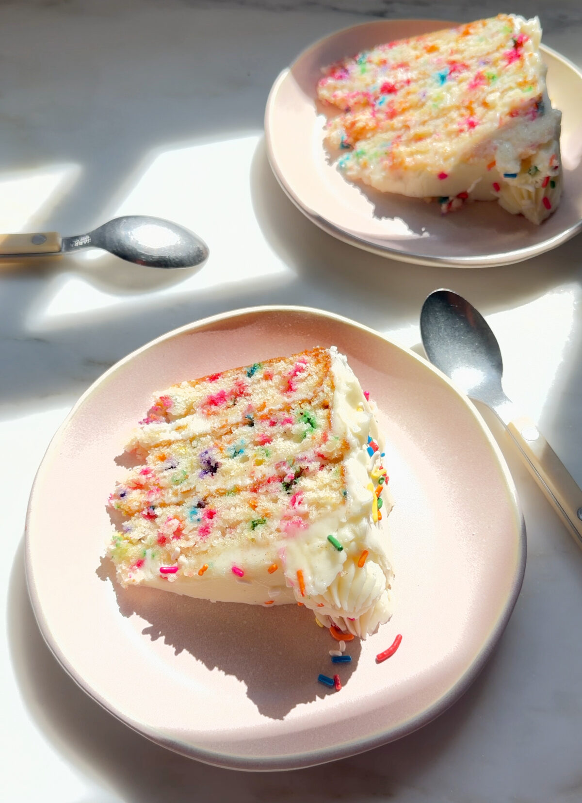 Slices of funfetti cake on plates.