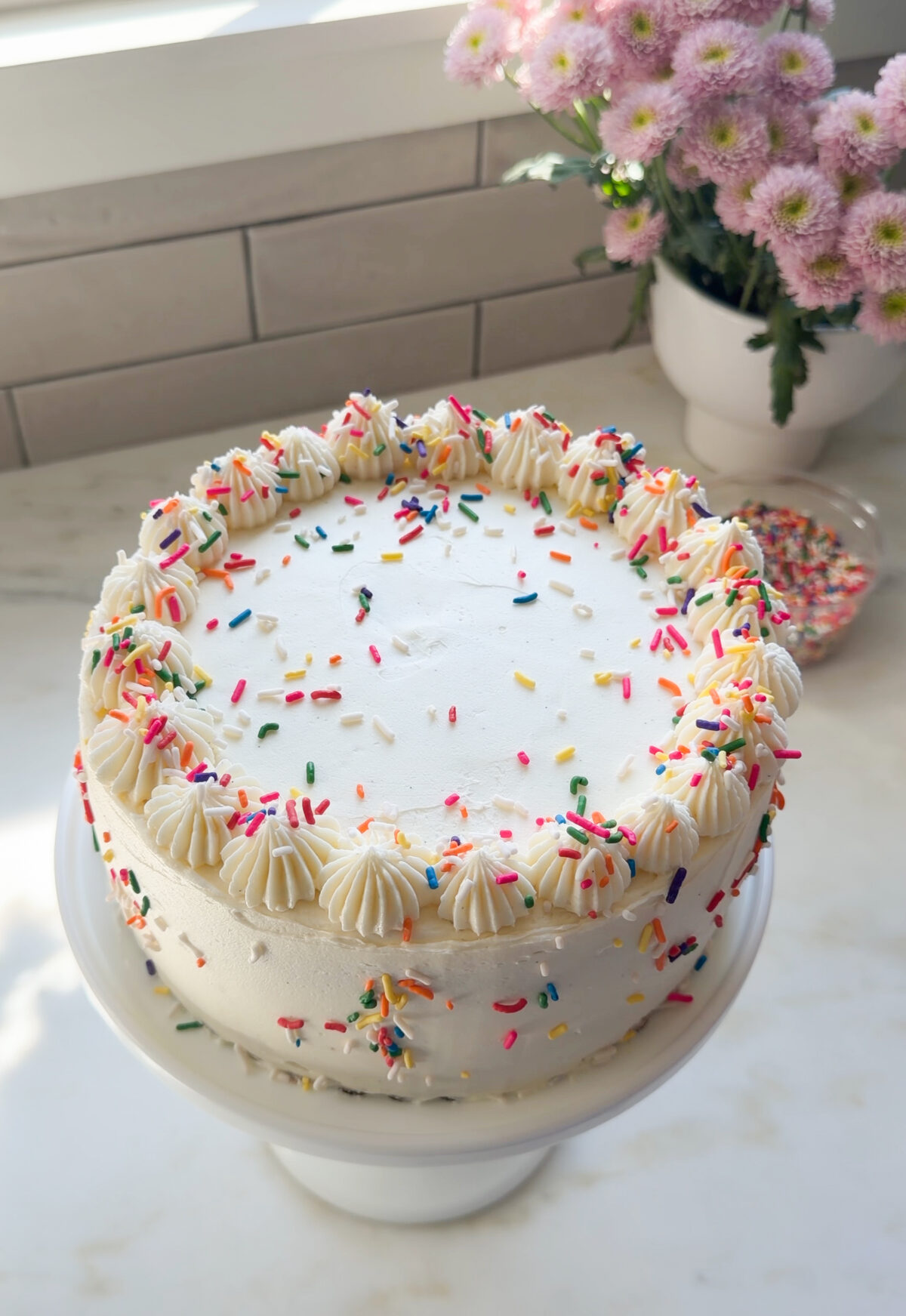 Funfetti cake decorated on cake stand.