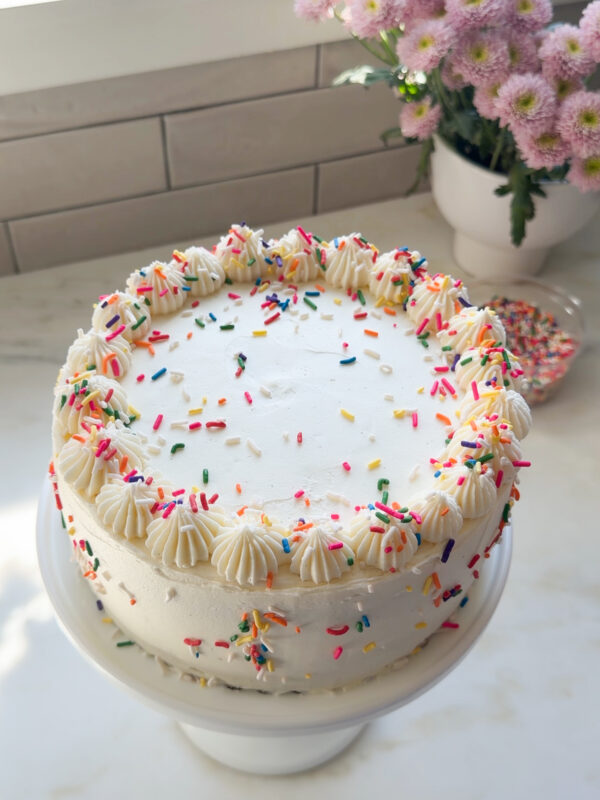 Funfetti cake decorated on cake stand.