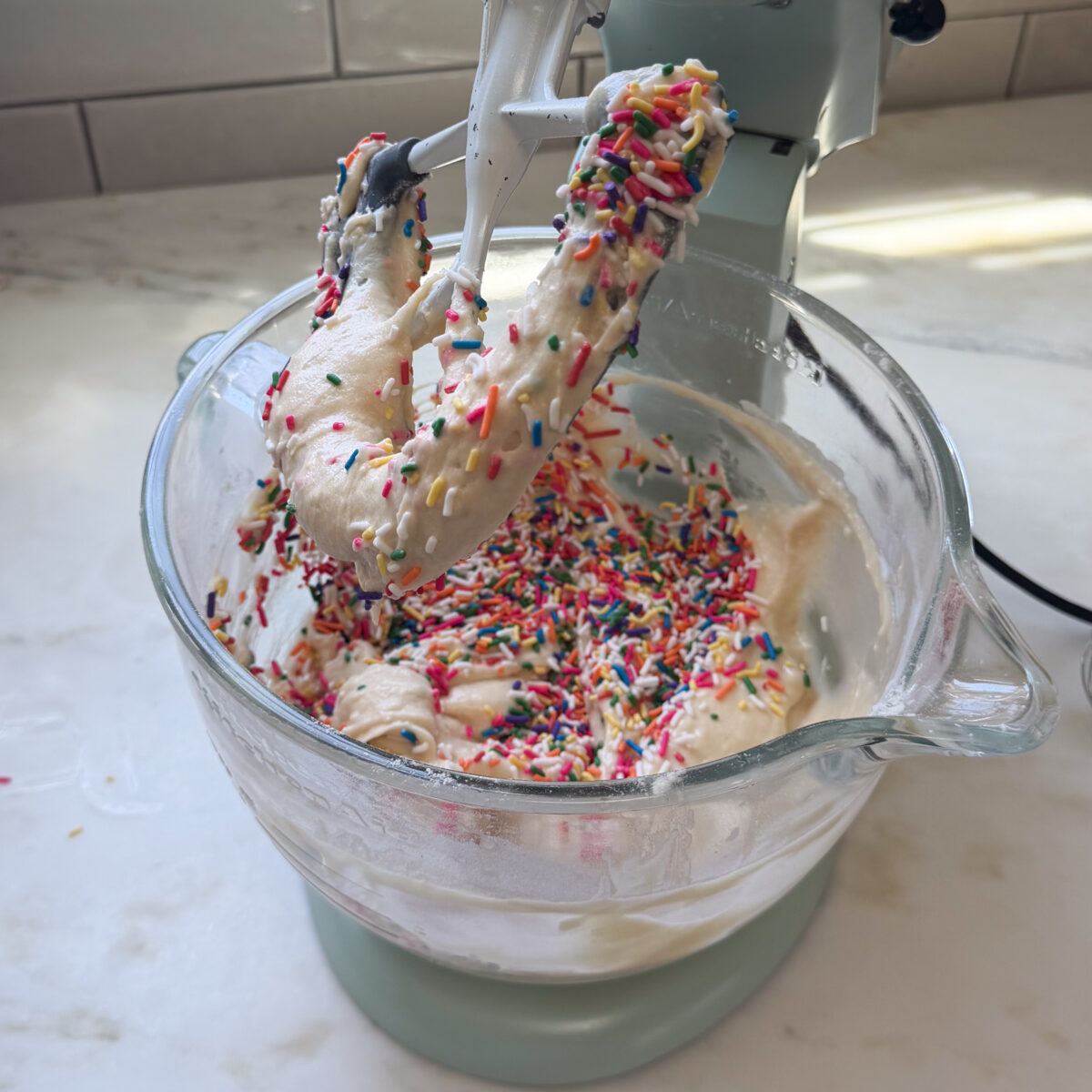 Mixing rainbow sprinkles into cake batter.