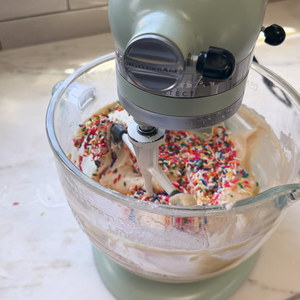 Mixing rainbow sprinkles into cake batter.