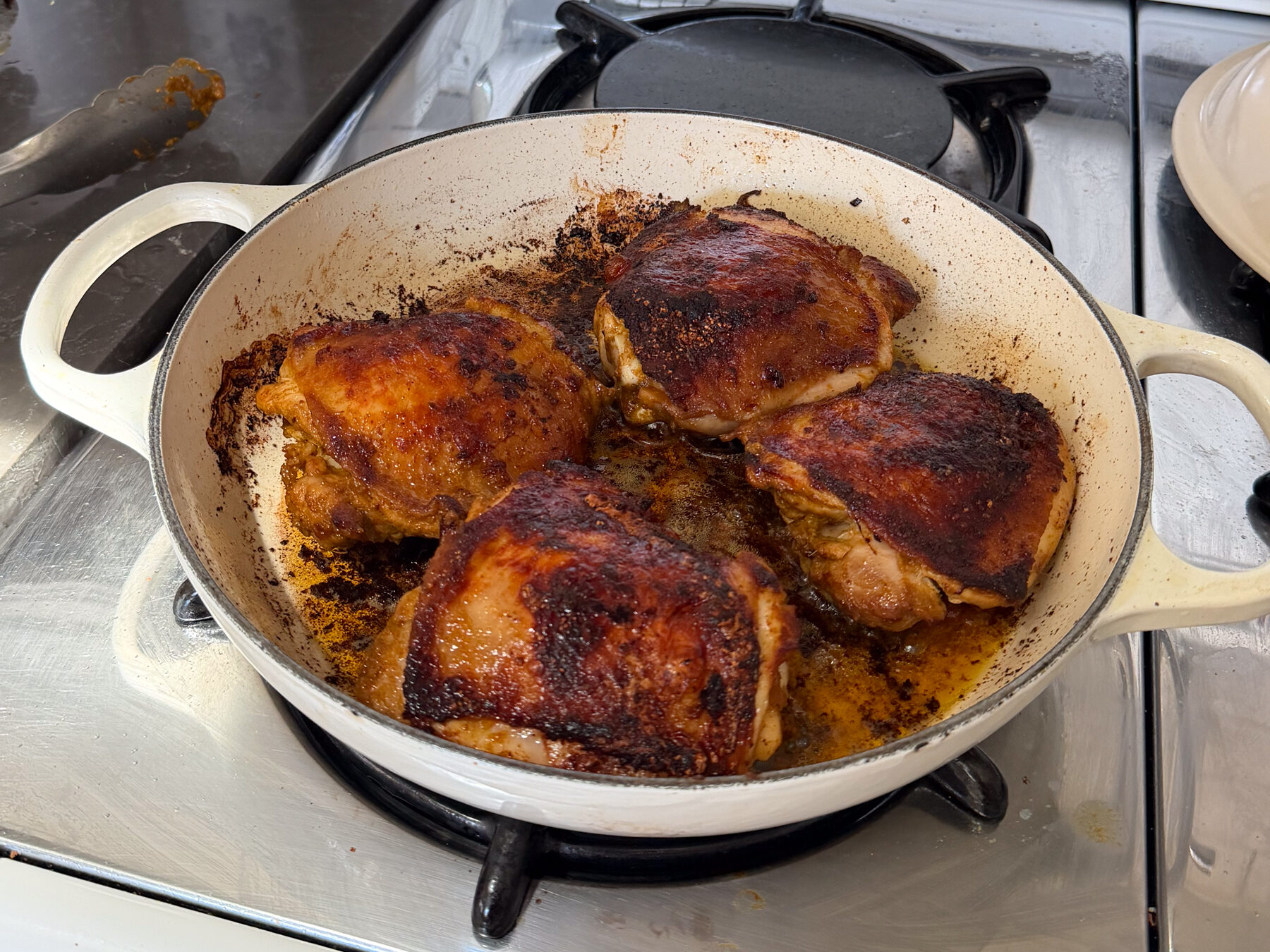 Seared chicken thighs in braiser.