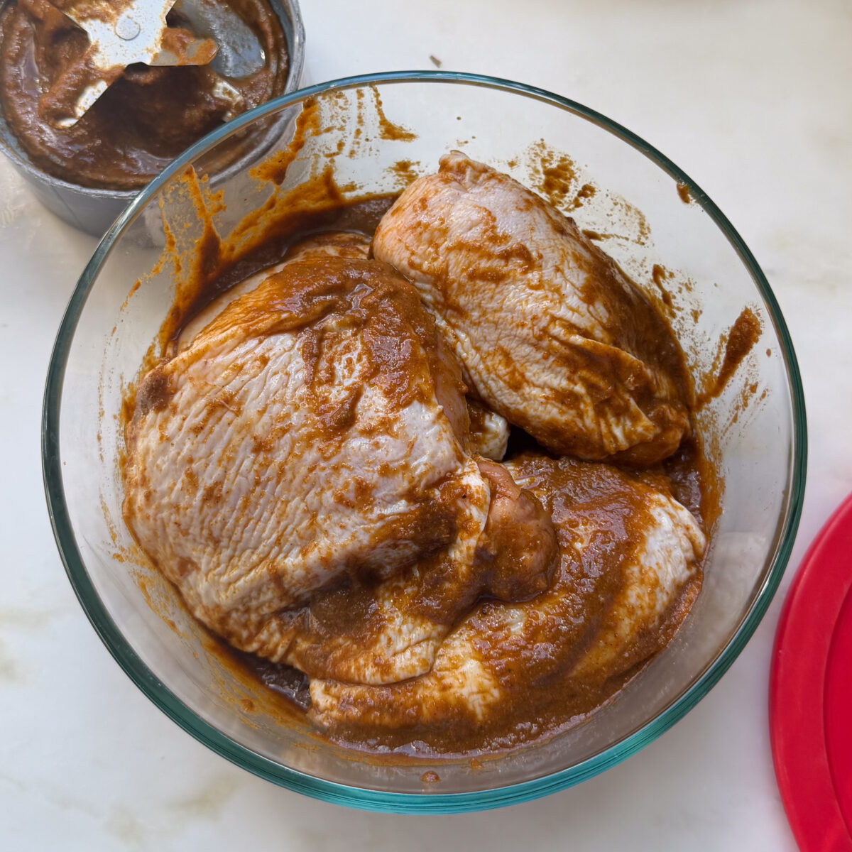 Chicken thighs in large bowl covered in marinade.