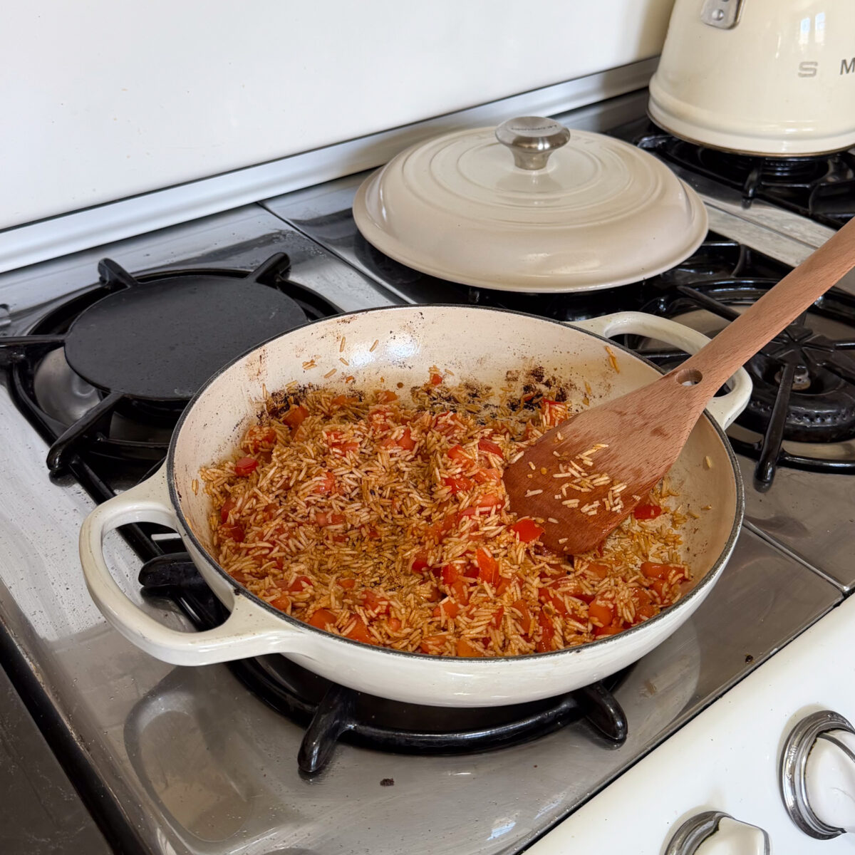 Rice with diced roma tomatoes in braiser.