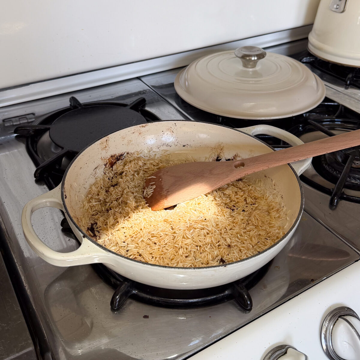 Toasting rice in residual chicken fat in braiser.
