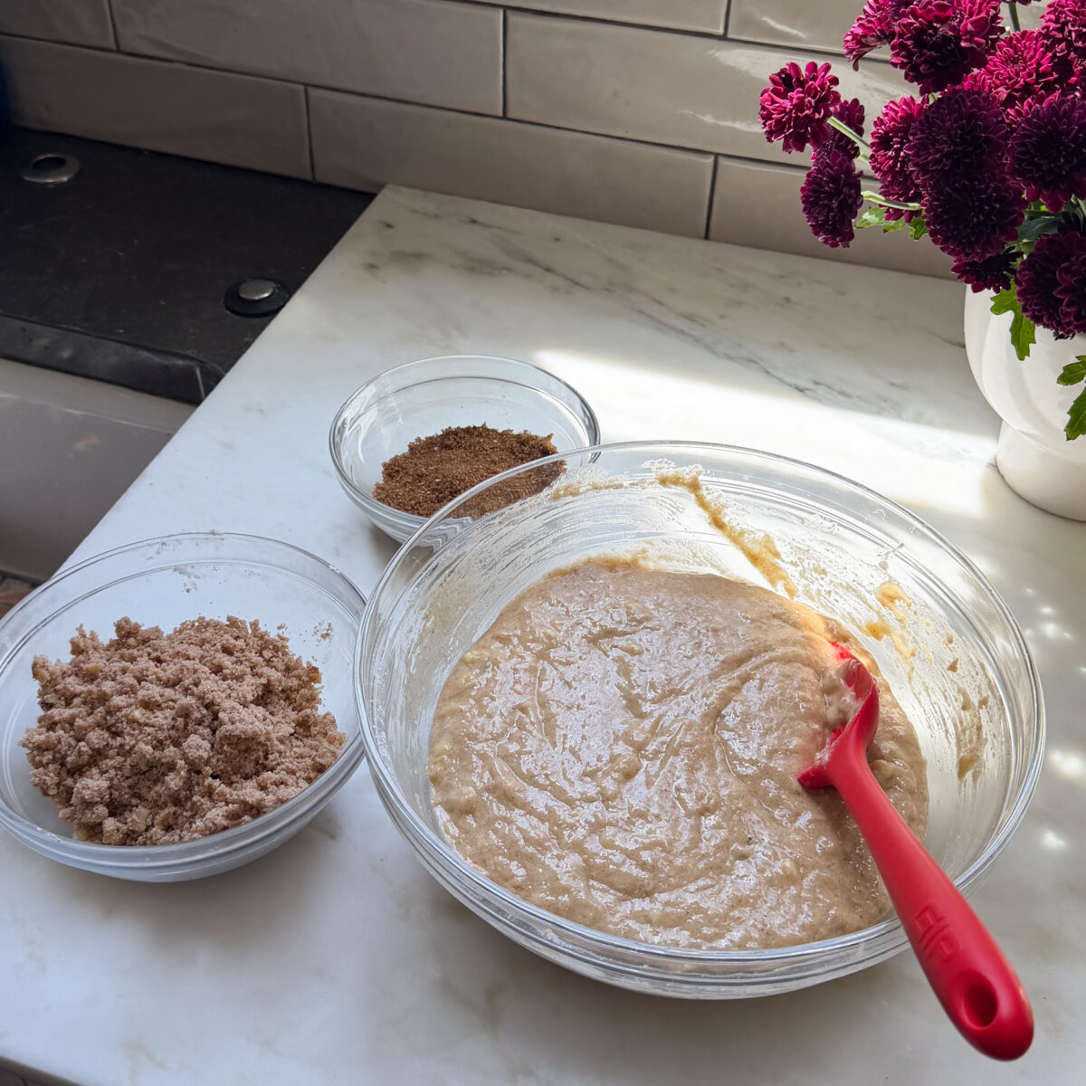 Banana bread coffee cake batter and layer components in bowls.