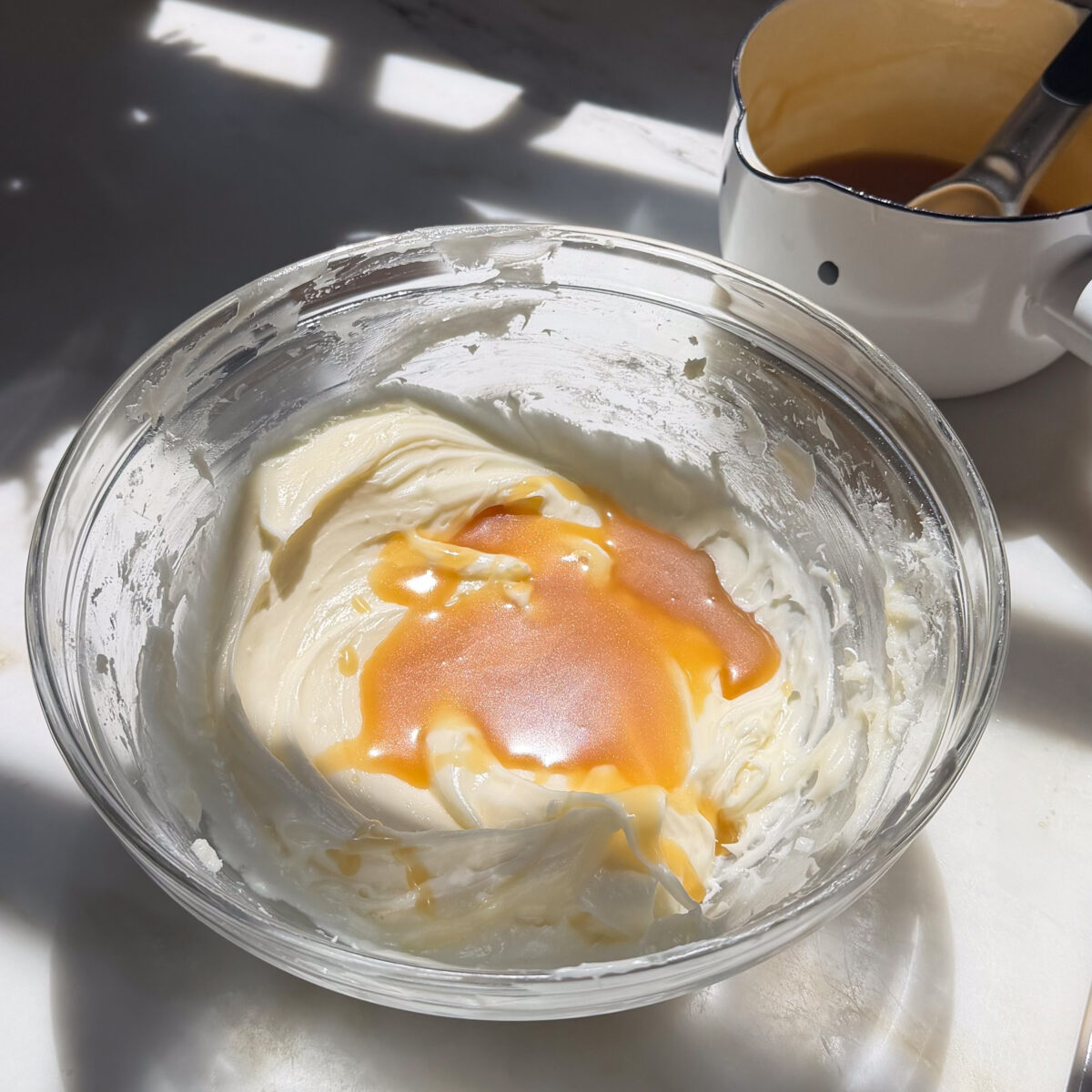 Adding salted maple caramel to cream cheese frosting.