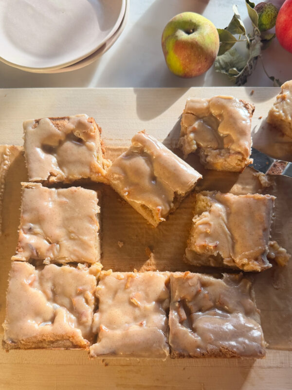 Sliced apple fritter brownies on cutting board.