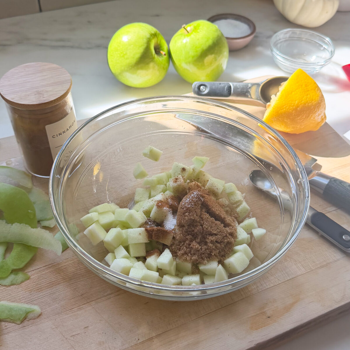 Diced apple in bowl with brown sugar and spices.