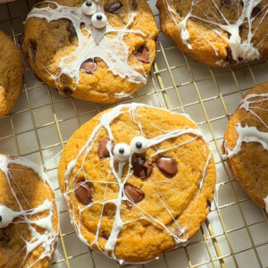 Decorated pumpkin chocolate chip cookies on cooling rack.