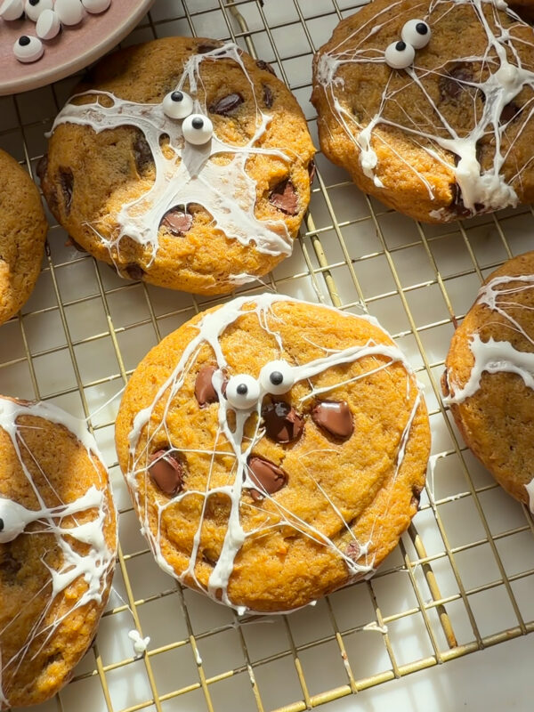 Decorated pumpkin chocolate chip cookies on cooling rack.