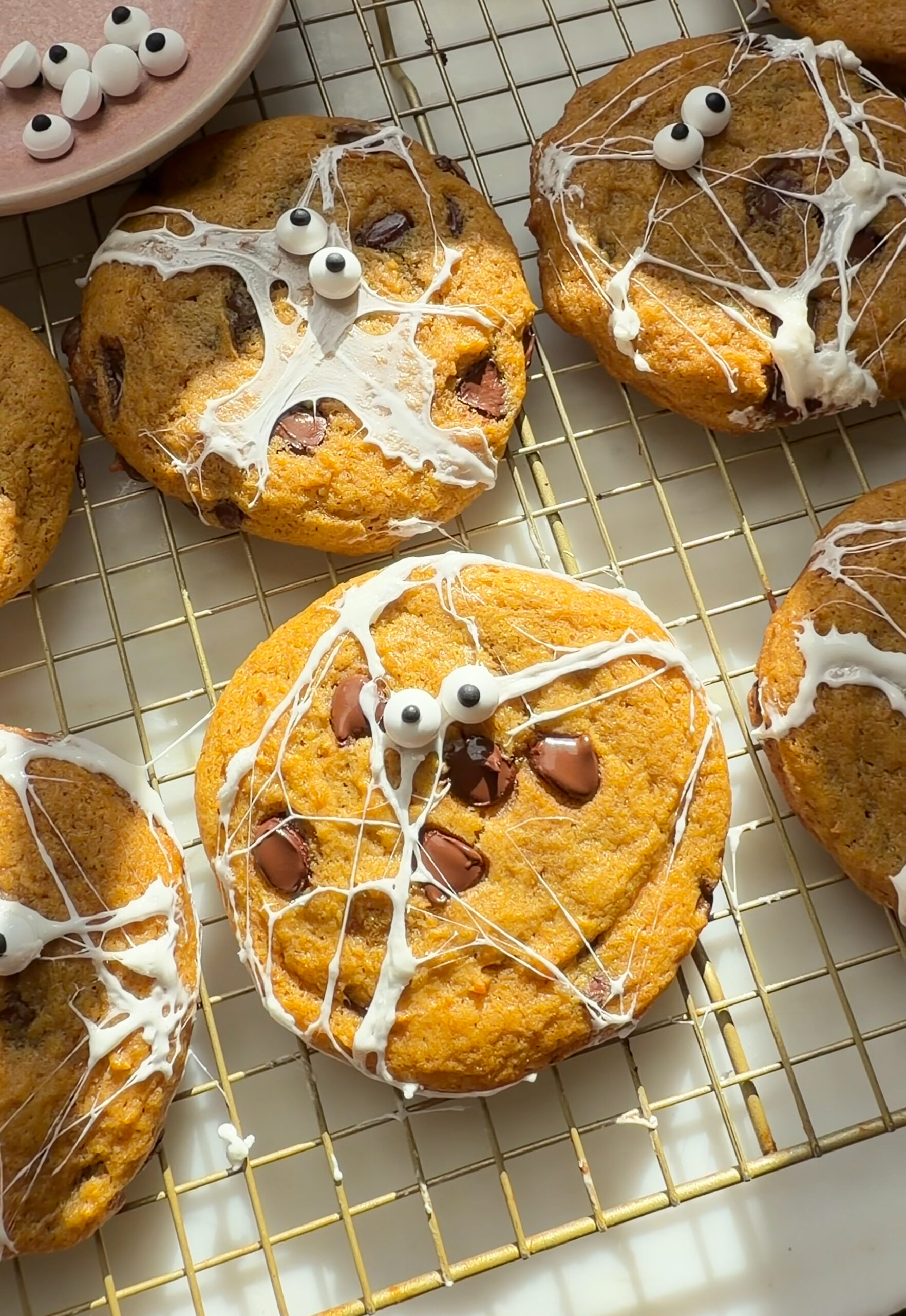 Decorated pumpkin chocolate chip cookies on cooling rack.