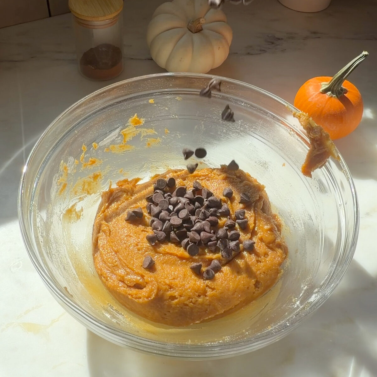 Cookie dough with chocolate chips on top in a large mixing bowl.