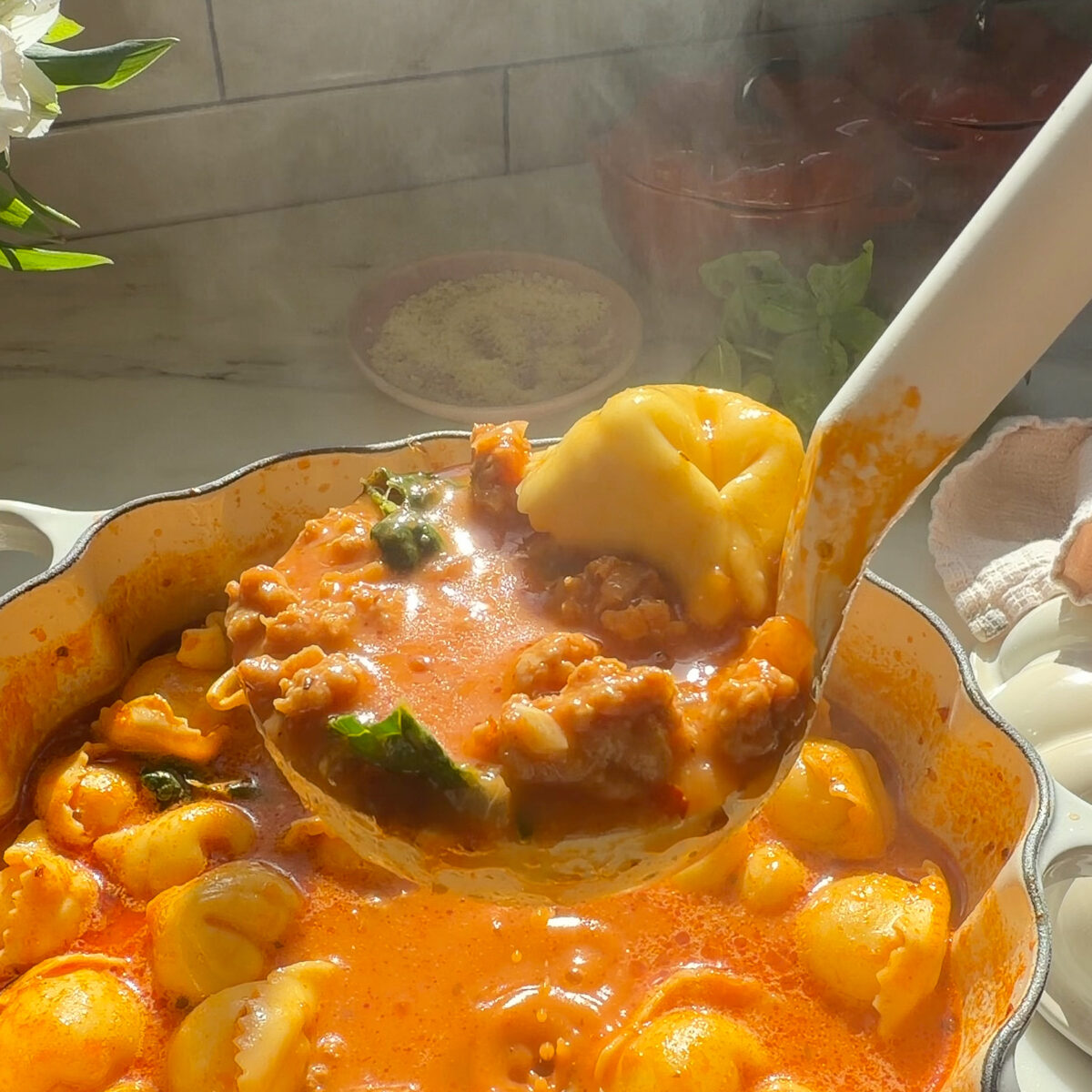 Ladle of tortellini soup.