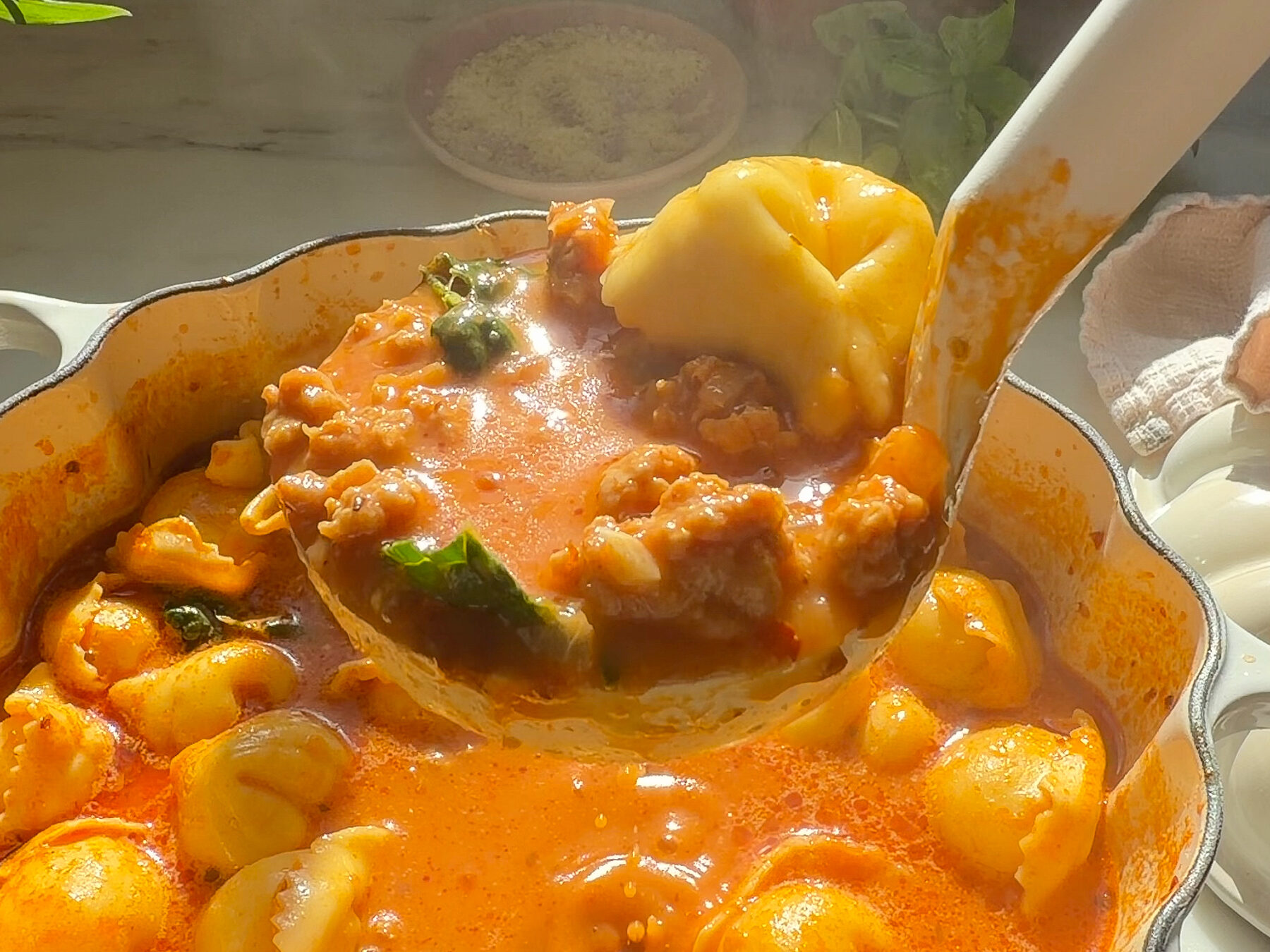 Ladle of tortellini soup.